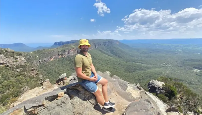 Visitor seated above a broad mountain valley